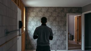 Électricien posant des gaines électriques sur un mur avant isolation